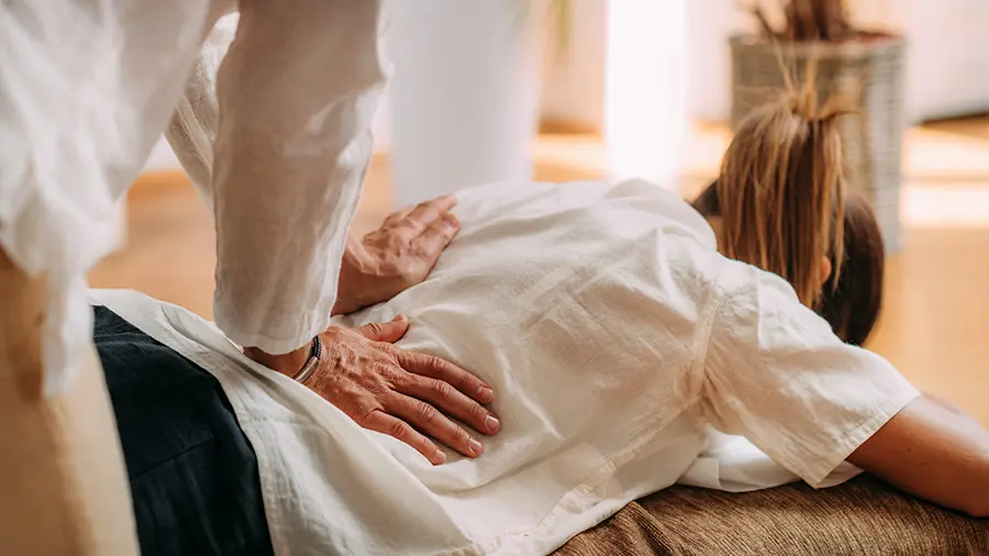 Un thérapeute pratique un shiatsu sur une cliente
